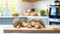 A selection of fresh vegetable: maitake mushroom, sitting on a chopping board against blurred kitchen background copy space