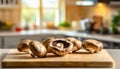 A selection of fresh vegetable: portobello mushroom, sitting on a chopping board against blurred kitchen background copy space