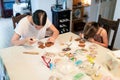 Culinary workshops for children. Two sisters decorating gingerbread cookies at home