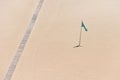 Flag and pathway on sandy beach