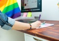 Cultura LGBTQIA. Woman working in office with LGBT accessories