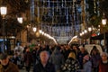 Cultural event of Artist lights with people walking in a street dressed in Christmas lights