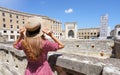 Cultural tourism in Italy. Beautiful tourist girl visiting ruins of Roman Amphitheater of the city of Lecce, Italy Royalty Free Stock Photo