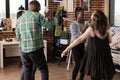 Culturally diverse couples of friends gladly dancing