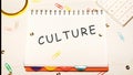 CULTURE word on a checkered notebook on a light table next to a magnifying glass, paper clips, stationery buttons, a calculator Royalty Free Stock Photo