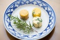 cultured butter pats with fresh herbs on porcelain plate