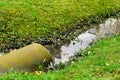 Culvert pipe hole system draining sewage water with little puddle in a rainy autumn day. Environmental pollution Royalty Free Stock Photo
