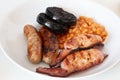 Cumberland sausages, bacon, baked beans and black pudding in a white bowl Royalty Free Stock Photo