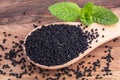 Cumin black seeds on wooden background, close up. Organic food