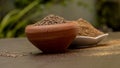 Cumin seeds called Jeera in clay bowl and it`s powder in white bowl on dark background. Royalty Free Stock Photo