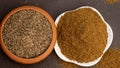 Cumin seeds called Jeera in clay bowl and it`s powder in white bowl on dark background. Royalty Free Stock Photo