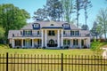 White Brick Mansion Behind Wrought Iron Fence