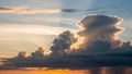 Cumulonimbus clouds are dramatically backlit by the setting sun, Royalty Free Stock Photo