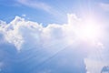 Cumulus and cirrus clouds and bright sunbeams against the blue sky. Atmospheric phenomenon, weather, summer