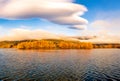 Cumulus cloud hovering over the Lakeside autumnal tree colour