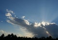 Cumulus cloud with sunbeam on beautiful blue sky , Silhouette of coconut palm tree with black color fluffy cloud at sunset