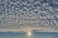 Cumulus clouds, blue sky and the evening sun with sun rays. Royalty Free Stock Photo