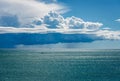 Cumulus Clouds with Torrential Rain on the Horizon over the Sea