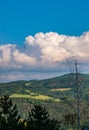 Cumulus congestus or towering cumulus - on the blue sky over hilly landscape