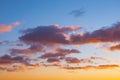 Cumulus sunset clouds with sun setting down bright gradient