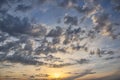 Cumulus sunset clouds with sun setting down