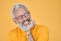 Cunning excited older funny man waiting with anticipation isolated on yellow. Royalty Free Stock Photo