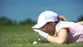 Cunning woman hitting golf ball in hole with finger, having fun during game Royalty Free Stock Photo