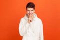 Cunning young man in casual style hoodie showing silence gesture, holding finger near lips and smiling, keep calm knowing secrets Royalty Free Stock Photo
