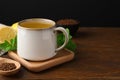 Cup of aromatic buckwheat tea and granules on wooden table, space for text