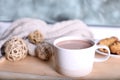 Cup of aromatic cacao on wooden tray near window