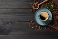 Cup of aromatic hot coffee and beans on black wooden table, flat lay. Space for text Royalty Free Stock Photo