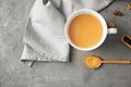 Cup of aromatic tea with milk on table, top view