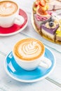 A cup of art coffee cappiciino and mini raw cakes