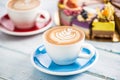 A cup of art coffee cappiciino and mini raw cakes Royalty Free Stock Photo