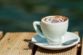 Cup of art latte on a cappuccino coffee isolated outside, on the beach.Morning coffee. white cup of latte hot coffee Royalty Free Stock Photo