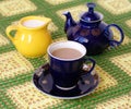 Cup of beverage. jug and teapot on back plane Royalty Free Stock Photo