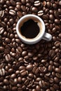 Cup of black coffee on a bed of roasted whole coffee beans. Top view photo. Food background with copy space Royalty Free Stock Photo