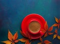 Cup of black coffee and branch of colorful autumn leaves Virginia creeper on a dark blue-green wooden table. Flat lay