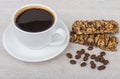 Cup of black coffee, cereal bars and coffee beans