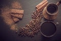 Cup of black coffee, coffee beans, chocolate bar, cinnamon and old cezve on black slate as background with copy space. Toned image Royalty Free Stock Photo