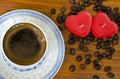 Cup of black coffee, coffee beans and heart shaped candles Royalty Free Stock Photo