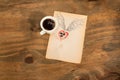 Cup of black coffee with coffee beans heart with wings drawn in pencil.