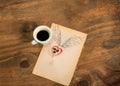 Cup of black coffee with coffee beans heart with wings drawn in pencil.