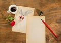 Cup of black coffee with coffee beans heart with wings drawn in pencil and red rose . Royalty Free Stock Photo