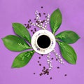 Cup of black coffee with flowers on purple coloured art background. Good Morning coffee floral setup.