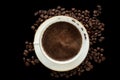 Cup of black coffee with foam on background of roasted coffee be Royalty Free Stock Photo