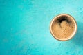 A cup of black coffee with froth, overhead flat lay shot on blue Royalty Free Stock Photo