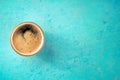 A cup of black coffee with froth, overhead flat lay shot on blue Royalty Free Stock Photo