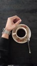 A cup of black coffee, a hand side by side with a cup of coffee on a black table,bitter coffee Royalty Free Stock Photo
