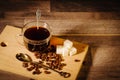 A cup of black coffee with lumps of sugar and coffee beans Royalty Free Stock Photo